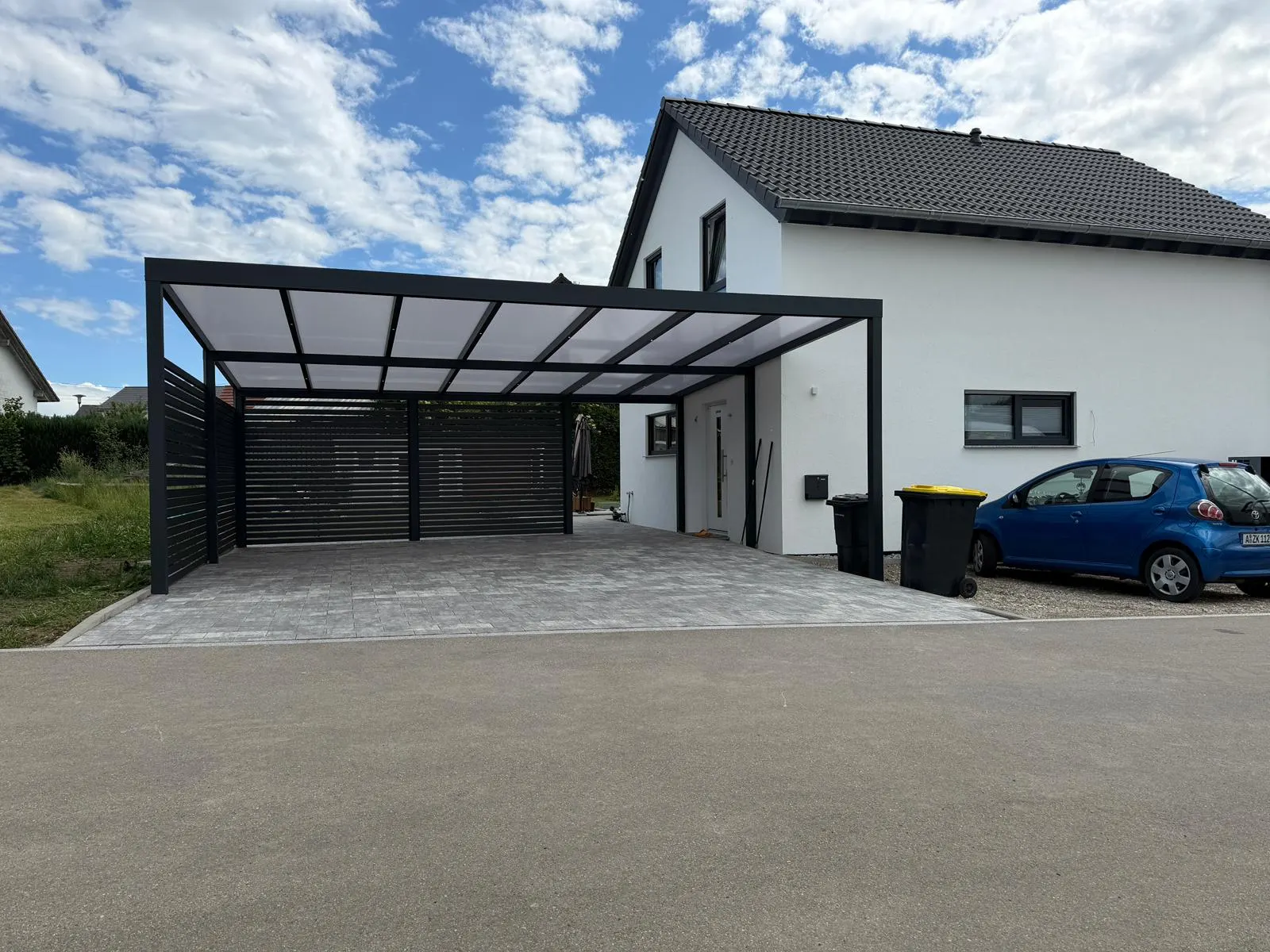 Carport in Kammeltal mit Seitenwand, Glas und Aluminium für Einfamilienhaus