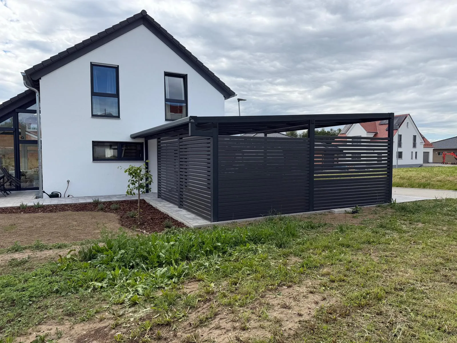 Carport in Kammeltal mit Seitenwand, Glas und Aluminium für Einfamilienhaus