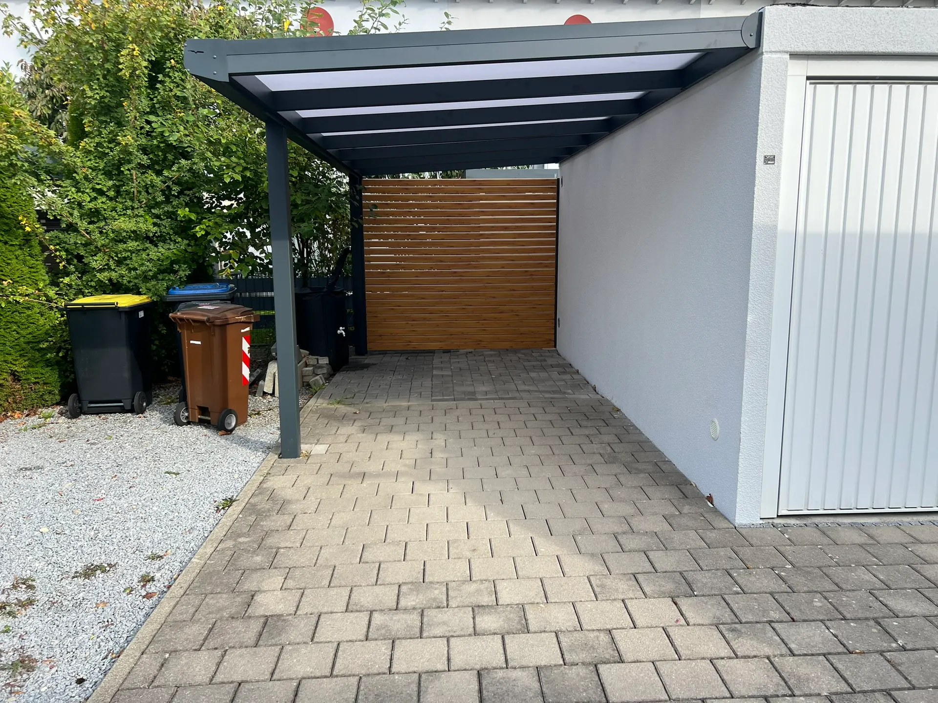 Carport mit Wandanschluss aus Aluminium in Gersthofen mit Polycarbonat-Dach und Seitenwand in Holzoptik