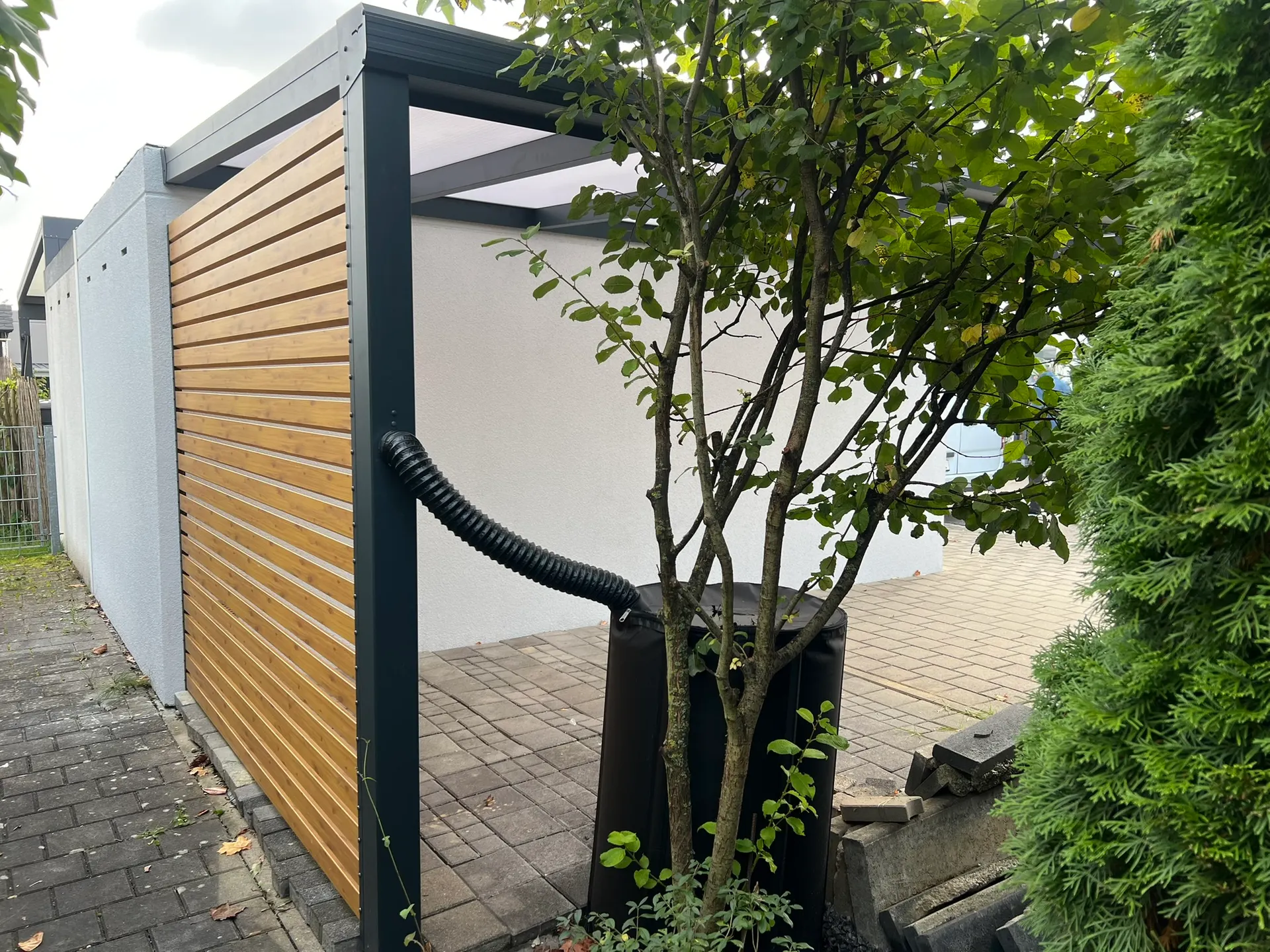 Carport mit Wandanschluss aus Aluminium in Gersthofen mit Polycarbonat-Dach und Seitenwand in Holzoptik